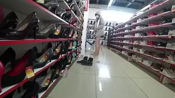 Voyeur and foot fetish in a public place. Beautiful legs in stockings and a juicy ass under a short dress in a shoe store.