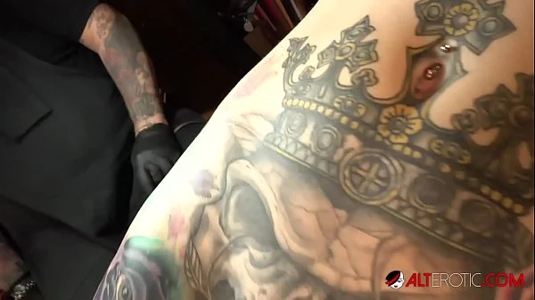 Marie Bossette touches herself while being tattooed