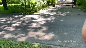 The girl topless is walking in the park in public